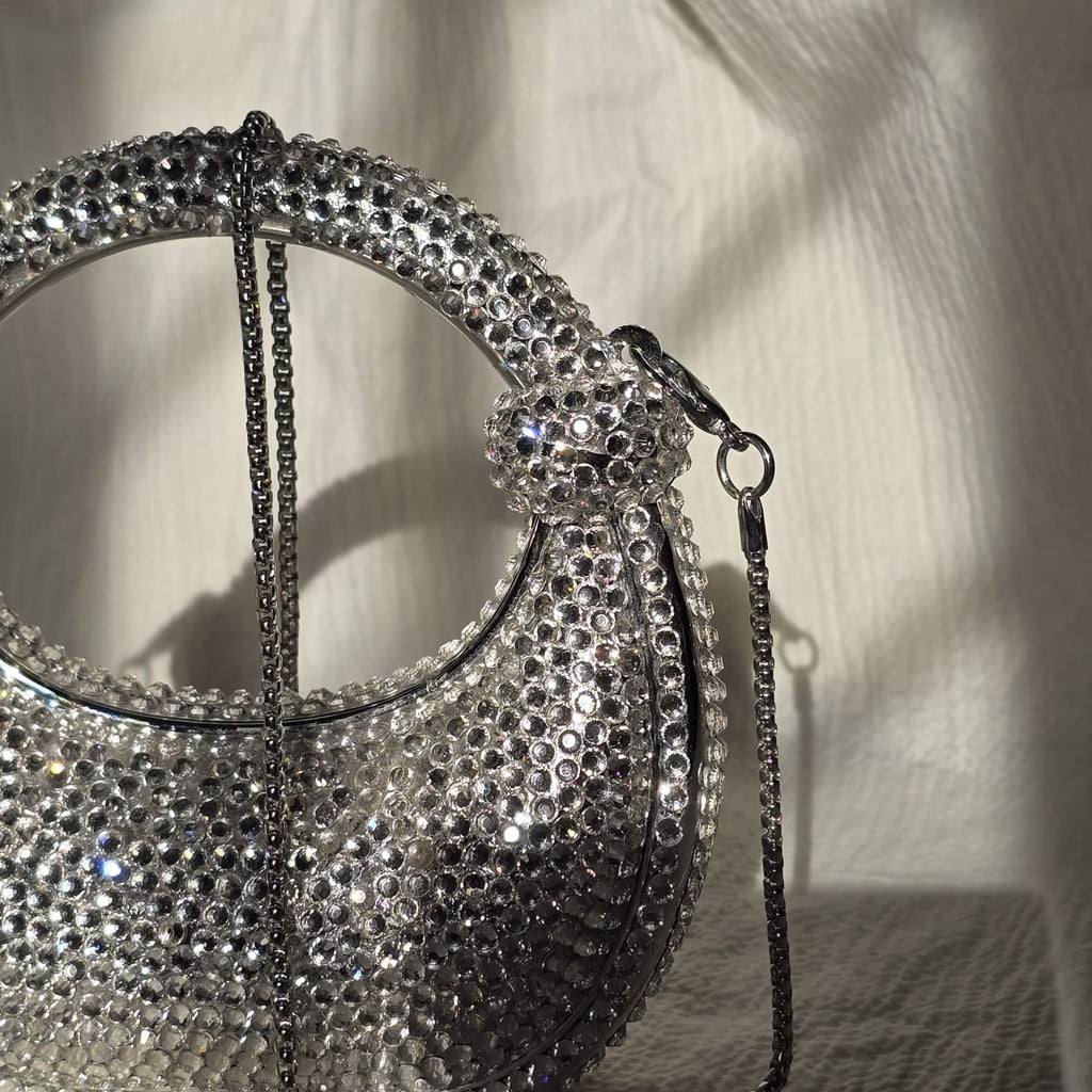 Detailed shot of the silver crystal bag showing how the rhinestones capture and reflect light for a high-glamour effect.